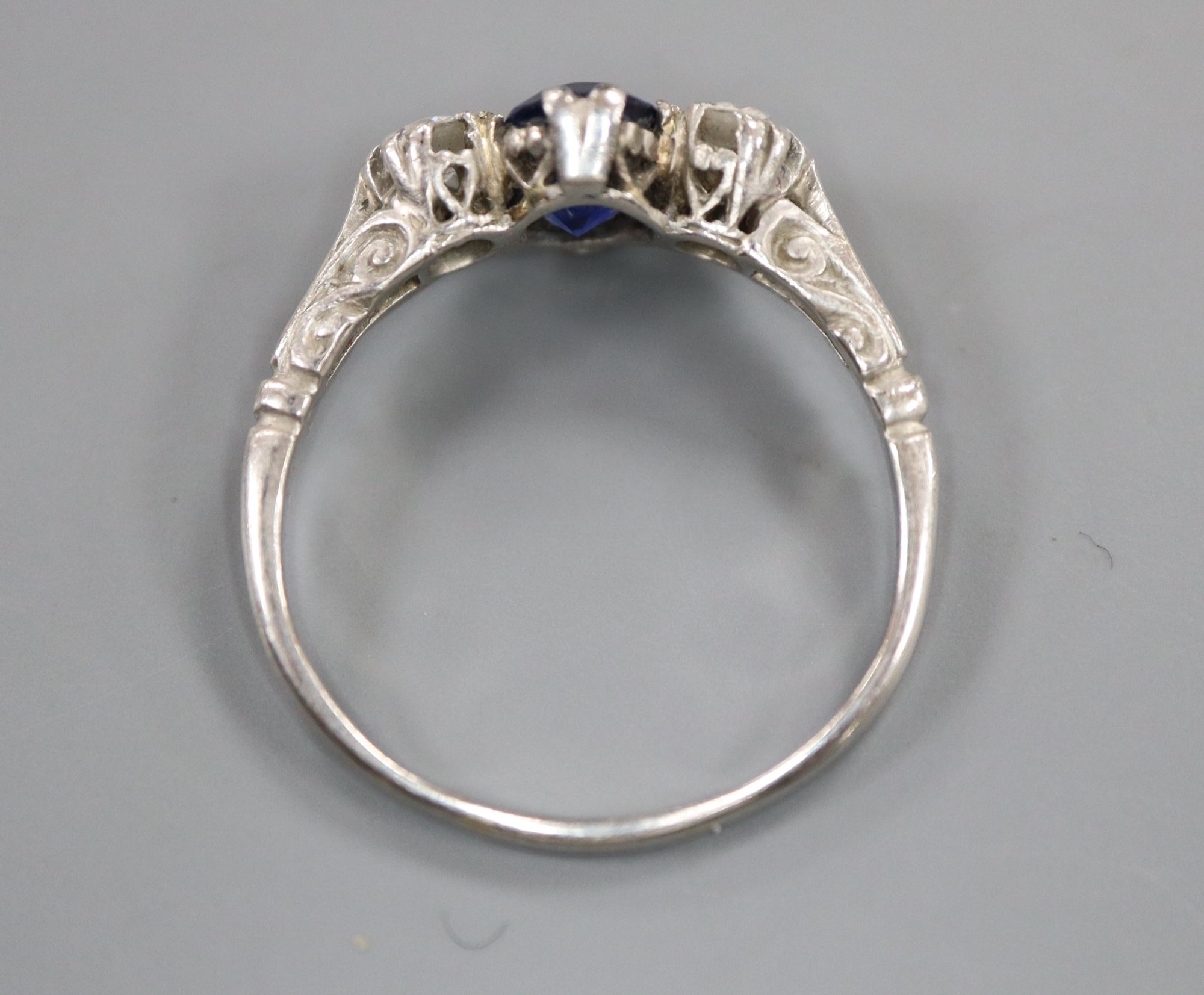 A mid 20th century white metal, sapphire and diamond three stone ring, size P, gross 3.6 grams.